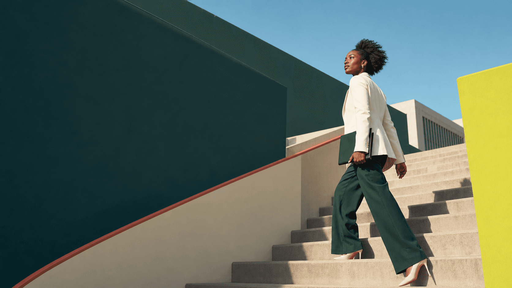 A professional moving confidently up a modern staircase